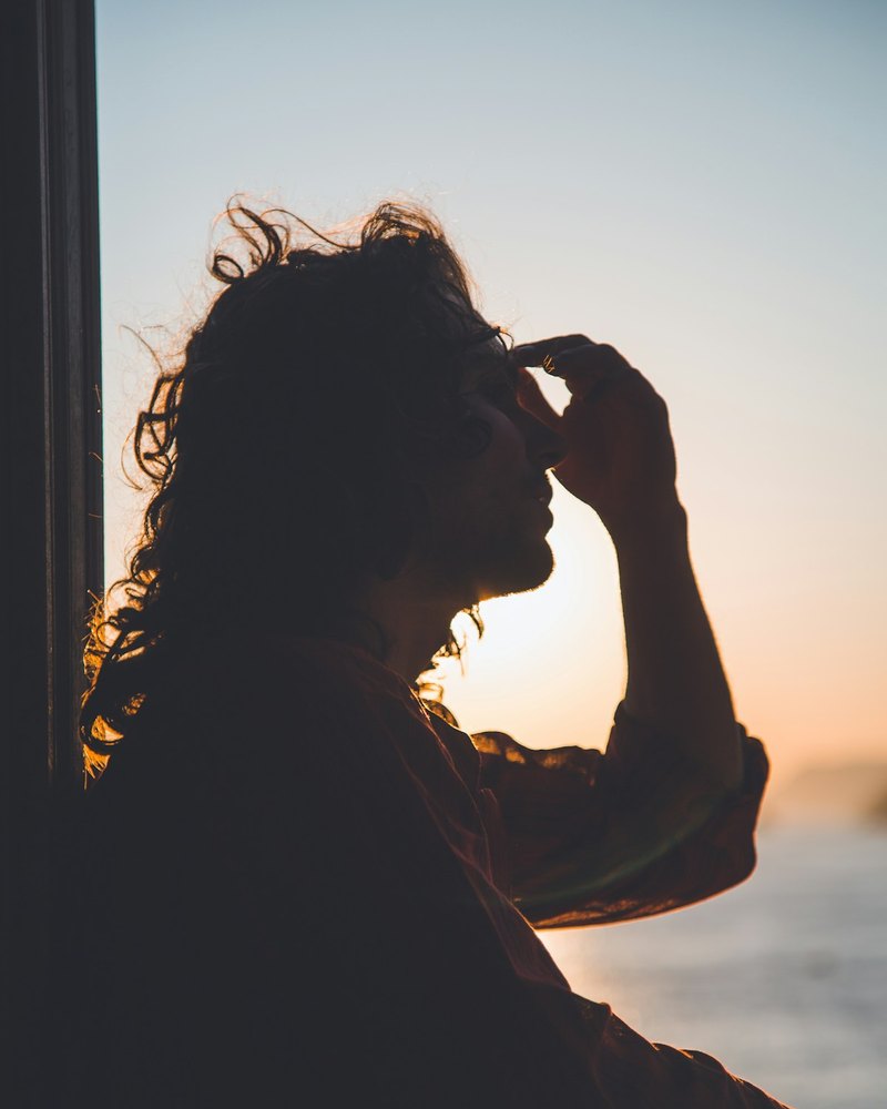 Une silhouette pensive face au coucher de soleil